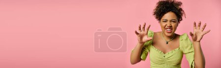 Téléchargez les photos : Femme afro-américaine en tenue élégante lève merveilleusement les mains dans un cadre vibrant. - en image libre de droit