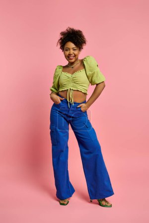 Foto de Beautiful African American woman striking a pose in stylish attire against a vibrant pink background. - Imagen libre de derechos