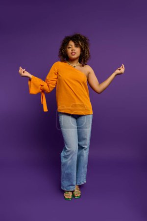 Téléchargez les photos : Femme afro-américaine en haut orange pose avec style sur un fond vibrant. - en image libre de droit