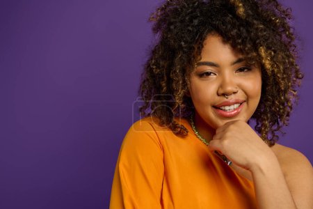 Photo for A beautiful African American woman in stylish attire, close-up shot showcasing an orange shirt. - Royalty Free Image