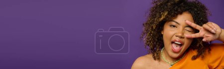 Une femme afro-américaine élégante faisant un drôle de visage avec ses mains dans un cadre vibrant.