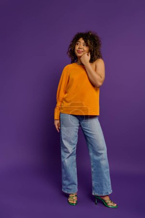 Téléchargez les photos : Femme afro-américaine élégante pose sur un fond violet vibrant. - en image libre de droit