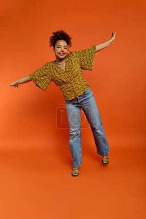 Téléchargez les photos : Femme afro-américaine élégante posant avec les bras tendus - en image libre de droit