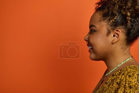 Foto de Una hermosa mujer afroamericana vestida con estilo, radiante de alegría en un vibrante telón de fondo. - Imagen libre de derechos