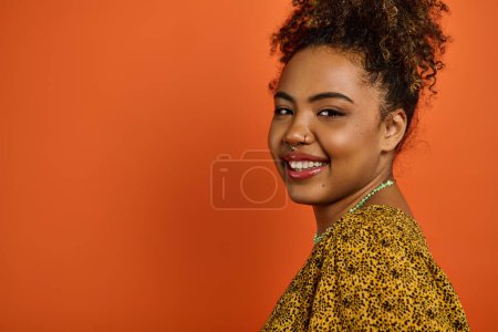 Photo for African American woman in stylish attire smiling warmly at the camera. - Royalty Free Image