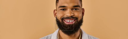 Photo for A man with a full, bushy beard grins warmly at the camera, his eyes sparkling with happiness and a hint of mischief. - Royalty Free Image