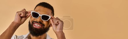 Photo for A man with a stylish beard wearing white sunglasses, exuding a cool and confident vibe as he gazes into the distance. - Royalty Free Image