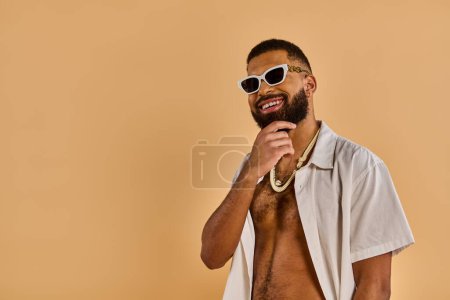 Ein Mann mit selbstbewusstem Auftreten trägt Sonnenbrille und modisches Hemd. Er strahlt Stil und Eleganz aus.