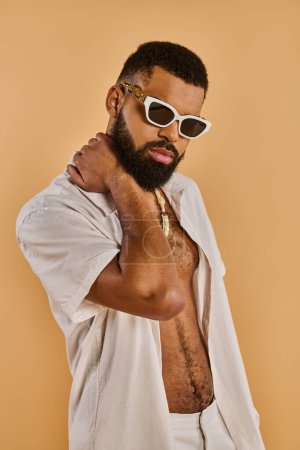 Ein stilvoller Mann mit Bart trägt selbstbewusst eine Sonnenbrille und ein knackig weißes Hemd und strahlt eine coole und trendige Stimmung aus..