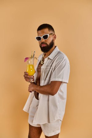 Ein Mann in einem knackig weißen Hemd hält zart ein Glas frischen Orangensaft in der Hand und zeigt einen Moment der Ruhe und Erfrischung..