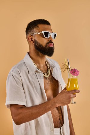 A stylish man wearing sunglasses is enjoying a drink in his hand, exuding an air of relaxation and sophistication.