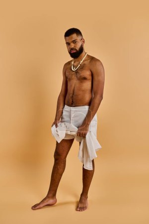 A bearded man stands confidently, draped in a white towel. His gaze is determined, exuding a sense of mystery and adventure.