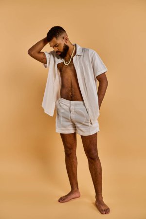 Photo for A shirtless man confidently stands before a warm, tan background, exuding strength and vitality in the golden light. - Royalty Free Image
