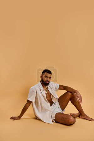Photo for A man sits on the ground with his legs crossed, deep in thought, his gaze focused ahead as if pondering the journey ahead. - Royalty Free Image