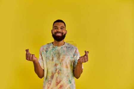 Photo for A lone man stands stoically in front of a vibrant yellow background, capturing the contrast between his figure and the bold color behind him. - Royalty Free Image