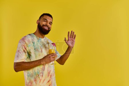 Photo for A man in a vibrant tie-dye shirt stands confidently, holding a classy wine glass. - Royalty Free Image