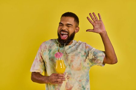 Foto de Un hombre con una barba exuberante agarrando una botella de jugo vibrante, exudando un aire de sofisticación y disfrute. - Imagen libre de derechos