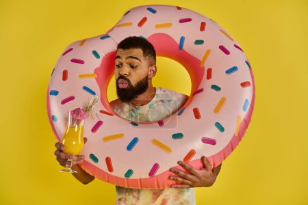 A man holds a giant donut in one hand and a glass of orange juice in the other, showcasing a delicious breakfast treat.
