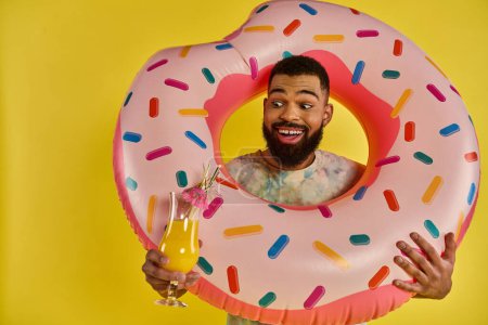 Un hombre sosteniendo alegremente un donut masivo y una bebida refrescante, mostrando un amor por deliciosas golosinas y relajación.