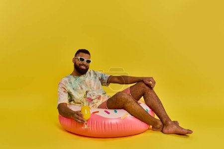 Téléchargez les photos : Un homme s'assied paisiblement sur un objet gonflable massif, méditant le monde autour de lui alors qu'il flotte doucement sur la surface des eaux. - en image libre de droit