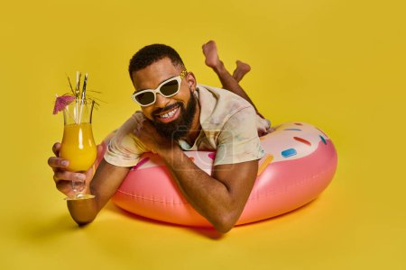 Un hombre se sienta tranquilamente en un flotador inflable en el agua, sosteniendo una bebida en su mano mientras disfruta de un momento de relajación.