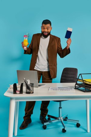 Un homme avec une expression sérieuse assis à un bureau, tenant une carte dans une main et tapant sur un ordinateur portable avec l'autre main.