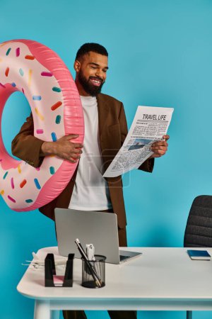 A man playfully holds a giant donut in front of his face, giving the illusion of wearing it like a mask.