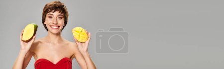 Téléchargez les photos : Jeune femme en robe rouge tenant deux fruits jaunes. - en image libre de droit