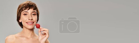Photo for Young woman holding strawberry near face. - Royalty Free Image