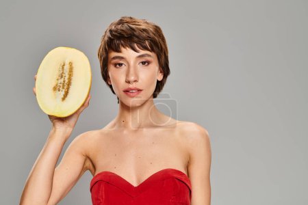 A woman in a red dress holding melon.