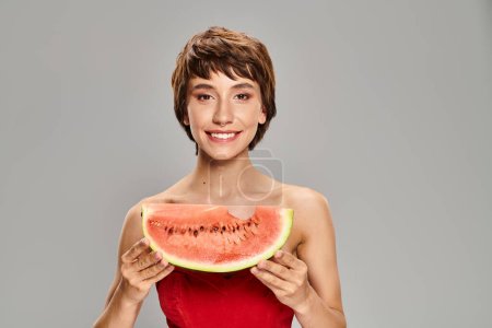 Photo for Elegant woman in red dress holding watermelon slice. - Royalty Free Image