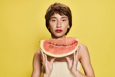 A young woman playfully holds a slice of watermelon in front of her face.