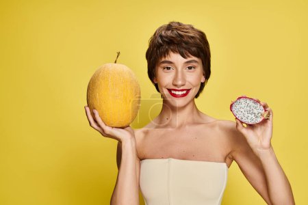 Téléchargez les photos : Jeune femme en robe blanche tient gracieusement un morceau de fruit. - en image libre de droit