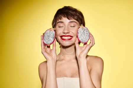 Photo for Young woman playfully holds two donuts in front of her face. - Royalty Free Image