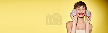 Téléchargez les photos : Une jeune femme tenant deux beignets devant son visage, créant une scène ludique et fantaisiste. - en image libre de droit
