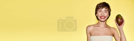 Photo for Elegant young woman in white dress poses holding mango. - Royalty Free Image