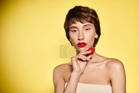 Mujer con fresa roja vibrante en los labios.
