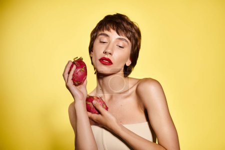 Une jeune femme tient paisiblement un fruit dans ses mains sur un fond vibrant.