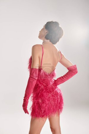 Téléchargez les photos : Une femme élégante dans une robe rose et des gants rouges pose élégamment. - en image libre de droit