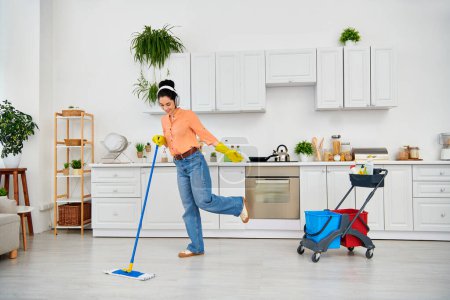 A stylish woman in casual attire gracefully mops the floor at home, adding elegance to her cleaning routine.