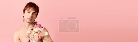 Téléchargez les photos : Un jeune homme aux cheveux roux porte en toute confiance une robe fleurie dans un décor studio, exsudant une fusion de masculinité et de féminité. - en image libre de droit
