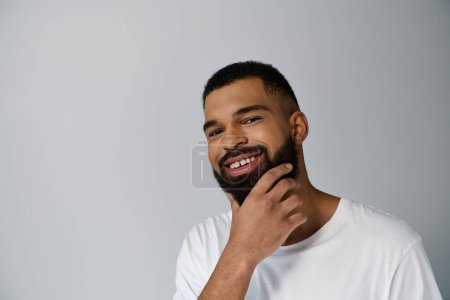 Photo for Handsome man in white t-shirt performing skincare routine. - Royalty Free Image