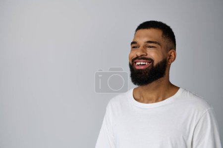 Foto de Hombre sonriente con barba en camisa blanca, disfrutando de la rutina de cuidado de la piel. - Imagen libre de derechos
