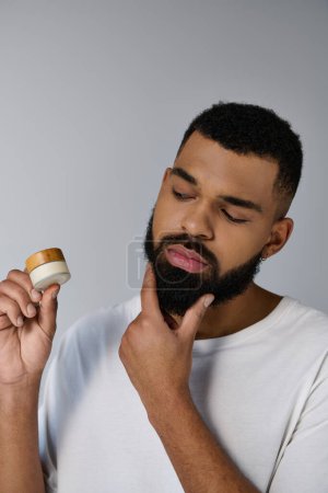 A bearded man holding cream.