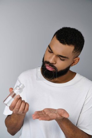 A stylish man with a beard carefully holds a grooming product in his hands.