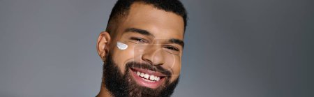 Photo for Handsome young man with a beard performing skincare routine. - Royalty Free Image