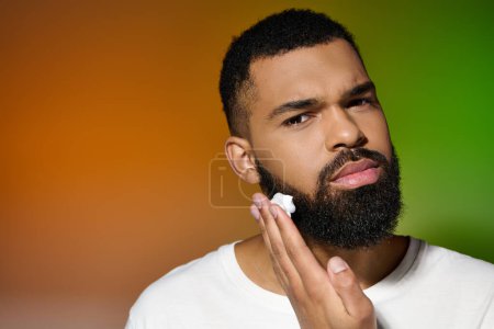 Africano americano atractivo hombre sostiene crema de afeitar.