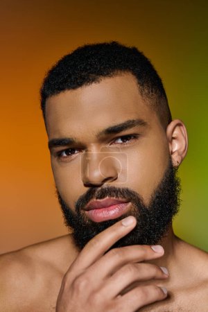 Photo for A shirtless man with a beard engaging in his skincare routine. - Royalty Free Image