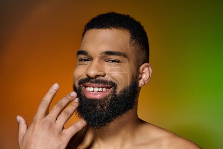 Un jeune homme souriant avec une barbe montrant sa routine de soins de la peau.