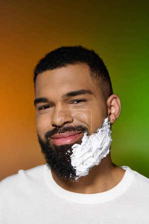 Africano americano jolly hombre usando afeitar crema.